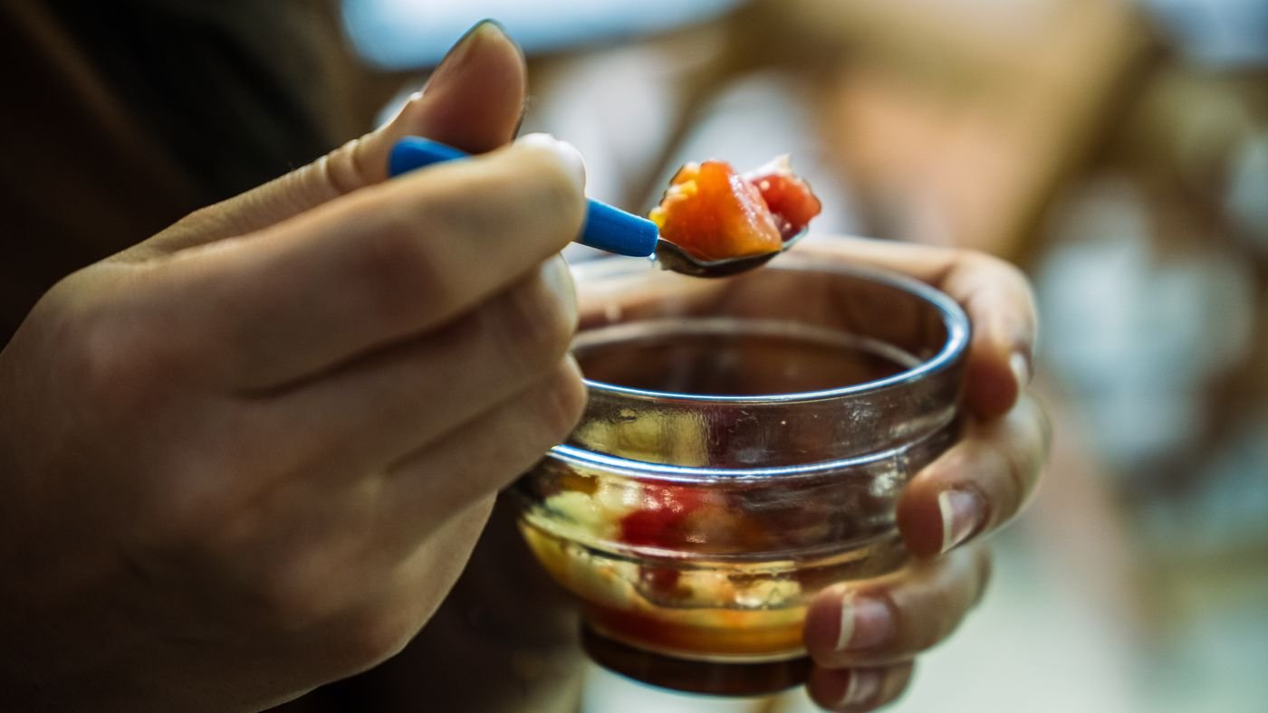 Hóspede se servindo de frutas frescas no café da manhã