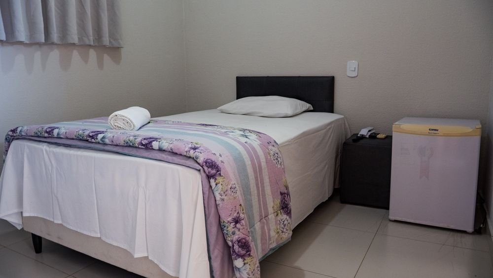 Apartamento individual do Hotel Katraca Palace com cama de solteiro e frigobar